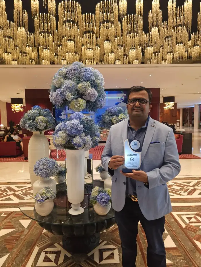 Vikas Agrawal holding the Outstanding Contribution award